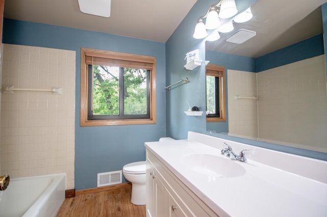 19715 Tyler St NW, Elk River, MN 55330 - full bathroom with wood finished floors, toilet, vanity, baseboards, and tub / shower combination