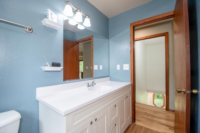 19715 Tyler St NW, Elk River, MN 55330 - half bathroom featuring wood finished floors, toilet, and vanity