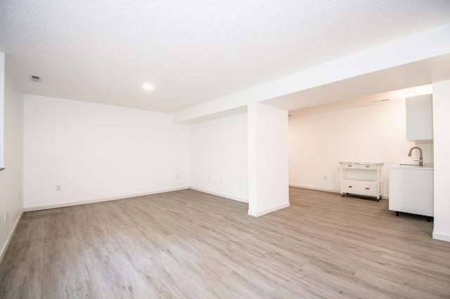 19715 Tyler St NW, Elk River, MN 55330 - finished below grade area featuring light wood-style floors, baseboards, a sink, and recessed lighting