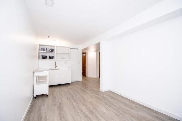 19715 Tyler St NW, Elk River, MN 55330 - unfurnished living room with a sink, light wood-style flooring, and baseboards