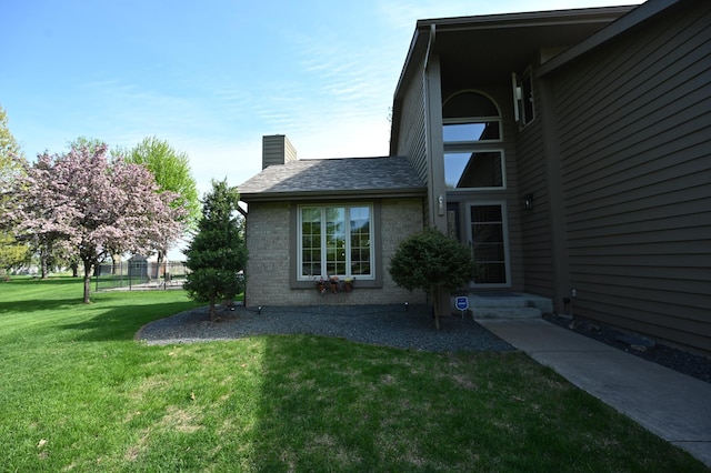 306 Windcrest Ln SE, New Prague, MN 56071 - view of side of home with a chimney, brick siding, and roof with shingles