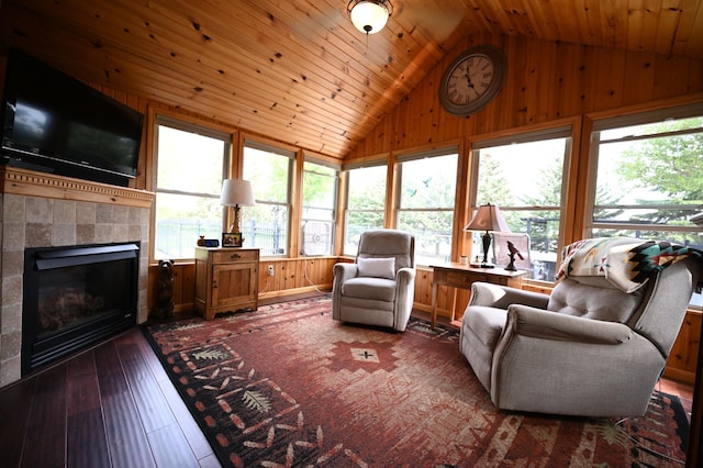 306 Windcrest Ln SE, New Prague, MN 56071 - living area featuring lofted ceiling, healthy amount of natural light, wood walls, a tile fireplace, and wooden ceiling