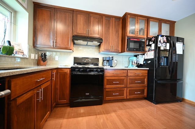 306 Windcrest Ln SE, New Prague, MN 56071 - kitchen with black appliances, under cabinet range hood, light wood-style floors, backsplash, and glass insert cabinets