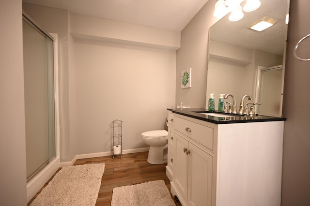 306 Windcrest Ln SE, New Prague, MN 56071 - full bathroom featuring a stall shower, wood finished floors, vanity, toilet, and baseboards
