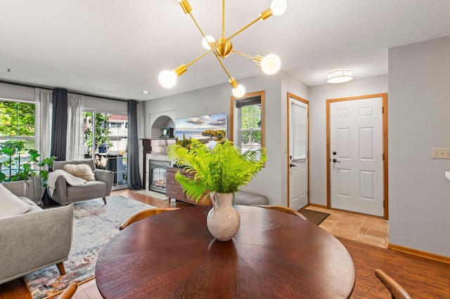 1925 Shenandoah Ct Unit F, Plymouth, MN 55447 - dining room with baseboards, a fireplace with flush hearth, wood finished floors, and a chandelier