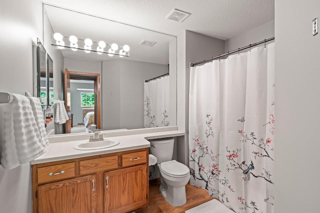 1925 Shenandoah Ct Unit F, Plymouth, MN 55447 - bathroom featuring wood finished floors, toilet, ensuite bath, vanity, and a textured ceiling