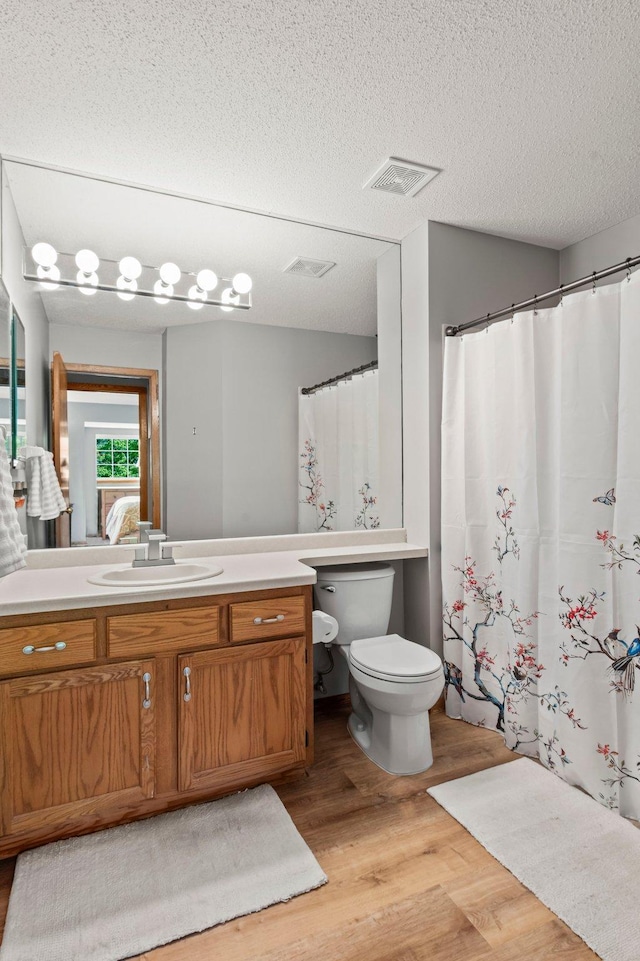 1925 Shenandoah Ct Unit F, Plymouth, MN 55447 - bathroom with wood finished floors, toilet, vanity, and a textured ceiling