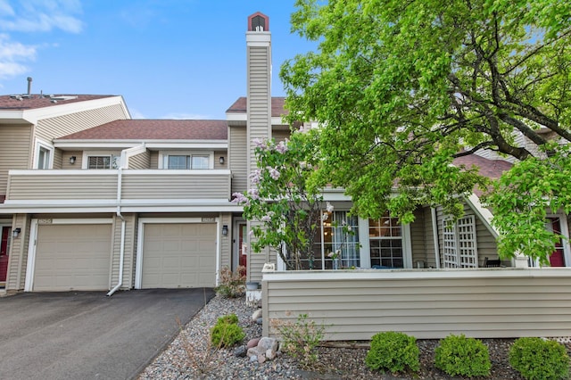 1925 Shenandoah Ct Unit F, Plymouth, MN 55447 - view of property featuring driveway, a balcony, a chimney, and an attached garage
