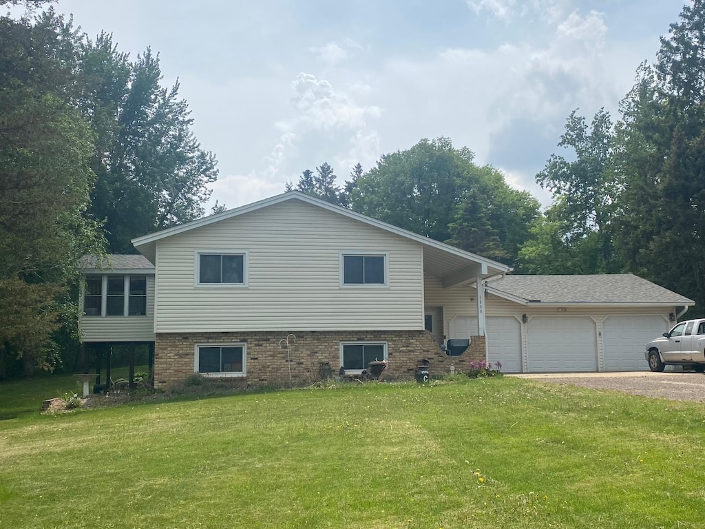 1550 181st Ave NW, Andover, MN 55011 - view of front of house featuring an attached garage, driveway, a front yard, and brick siding