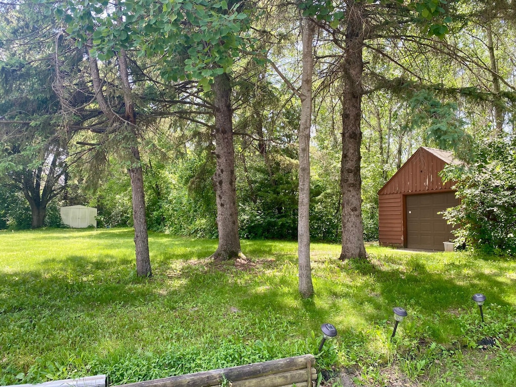 1550 181st Ave NW, Andover, MN 55011 - view of green lawn with an outdoor structure and a detached garage