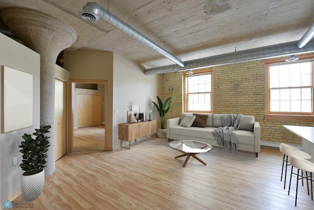 210 11th St N Unit 202, Fargo, ND 58102 - living room featuring brick wall, wood finished floors, and baseboards