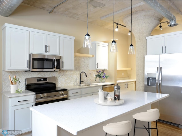 210 11th St N Unit 202, Fargo, ND 58102 - kitchen with appliances with stainless steel finishes, backsplash, a center island, a sink, and a breakfast bar