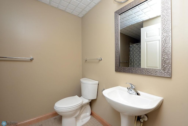 210 11th St N Unit 202, Fargo, ND 58102 - bathroom with baseboards, a sink, toilet, and a shower with shower curtain