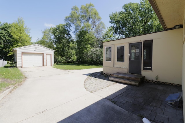 718 1st St SW, Faribault, MN 55021 - view of patio with an outdoor structure, driveway, and a detached garage