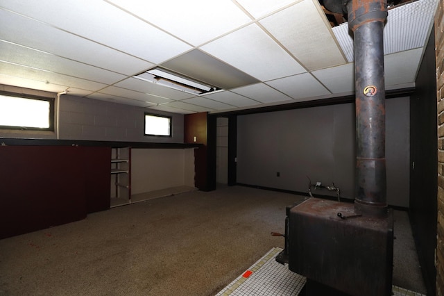 718 1st St SW, Faribault, MN 55021 - basement with carpet, a paneled ceiling, and a wood stove