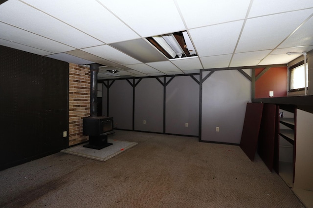 718 1st St SW, Faribault, MN 55021 - basement with a paneled ceiling, a wood stove, and carpet