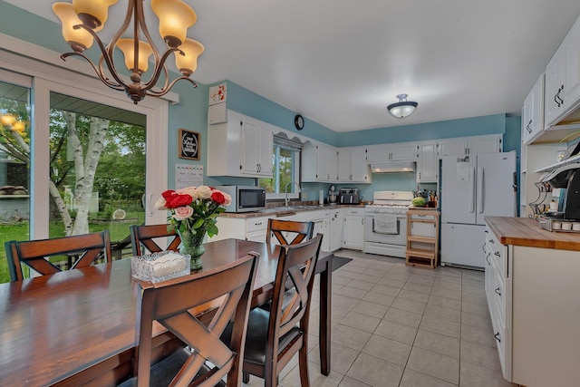 830 Halliday Rd, Saint Cloud, MN 56301 - kitchen with white appliances, under cabinet range hood, a sink, light tile patterned floors, and plenty of natural light