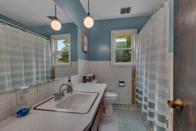 830 Halliday Rd, Saint Cloud, MN 56301 - full bathroom featuring tile walls, plenty of natural light, vanity, toilet, and tile patterned flooring