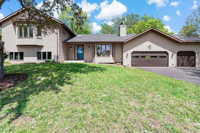 77 Emerson Ave W, West Saint Paul, MN 55118 - split level home with a garage, driveway, a chimney, and a front yard