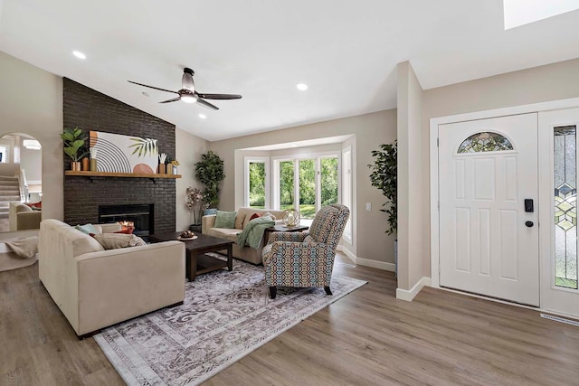 77 Emerson Ave W, West Saint Paul, MN 55118 - living area featuring ceiling fan, light wood-style flooring, a brick fireplace, baseboards, and vaulted ceiling