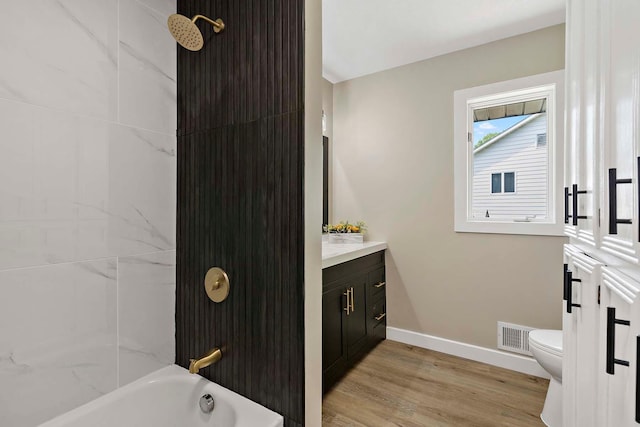 77 Emerson Ave W, West Saint Paul, MN 55118 - bathroom featuring baseboards, vanity, toilet, wood finished floors, and shower / washtub combination