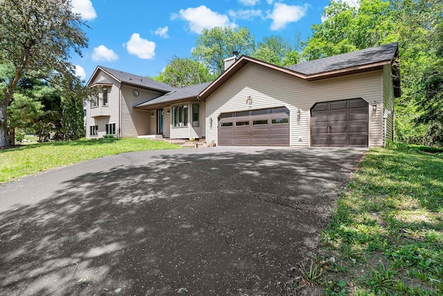 77 Emerson Ave W, West Saint Paul, MN 55118 - split level home with an attached garage, asphalt driveway, a chimney, and a front lawn