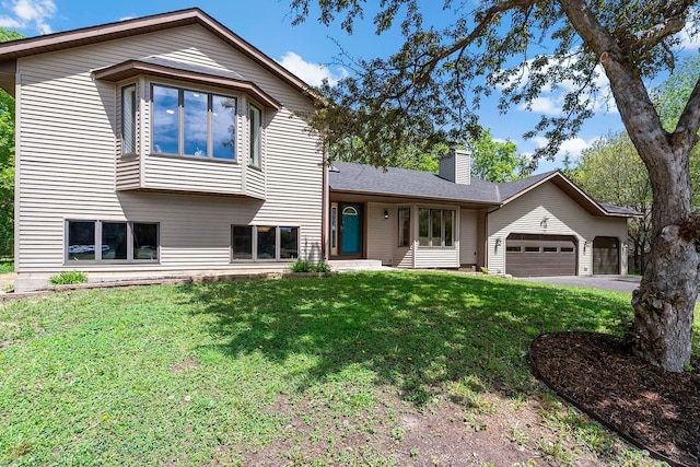 77 Emerson Ave W, West Saint Paul, MN 55118 - tri-level home with a chimney, a garage, a front lawn, and driveway