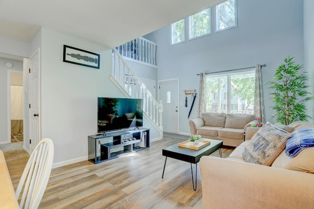 2714 18th Ave S, Minneapolis, MN 55407 - living area featuring stairway, wood finished floors, baseboards, and a towering ceiling