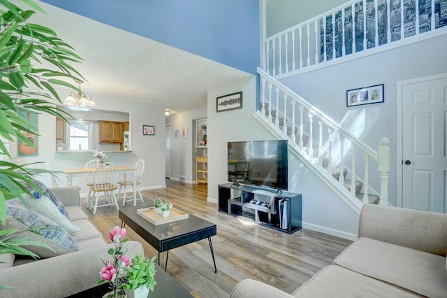 2714 18th Ave S, Minneapolis, MN 55407 - living area featuring stairway, wood finished floors, baseboards, and a towering ceiling