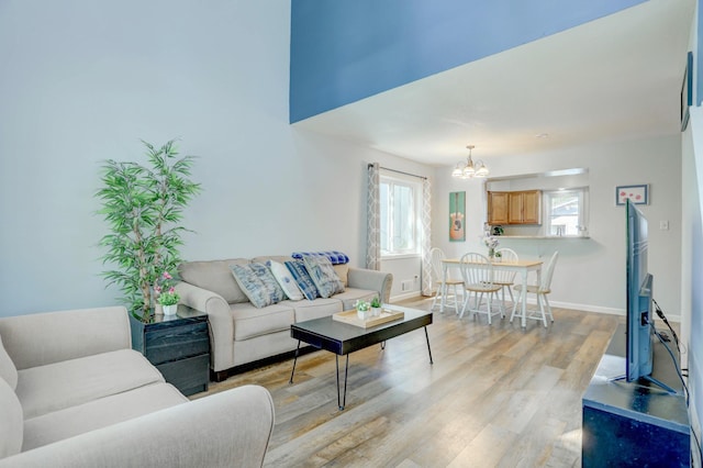 2714 18th Ave S, Minneapolis, MN 55407 - living area with a chandelier, light wood-style floors, and baseboards