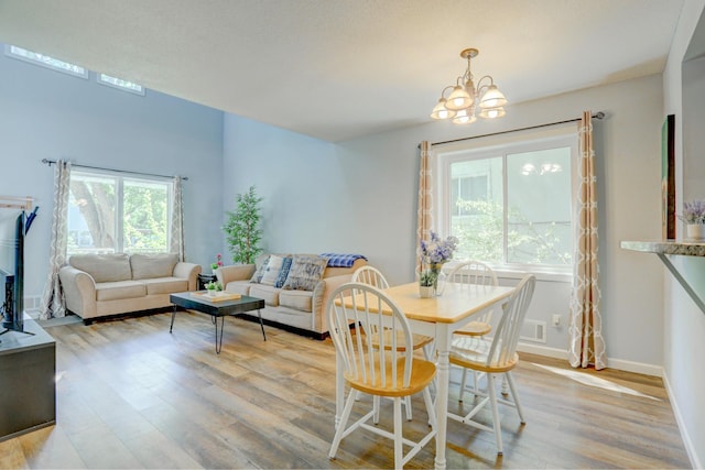 2714 18th Ave S, Minneapolis, MN 55407 - dining space with light wood-type flooring, a chandelier, and baseboards