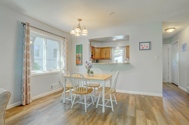 2714 18th Ave S, Minneapolis, MN 55407 - dining area with a chandelier, light wood-type flooring, and baseboards