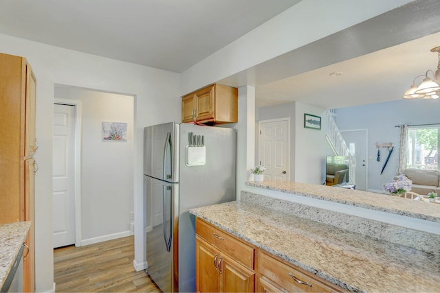2714 18th Ave S, Minneapolis, MN 55407 - kitchen with freestanding refrigerator, light wood-type flooring, light stone countertops, baseboards, and a chandelier