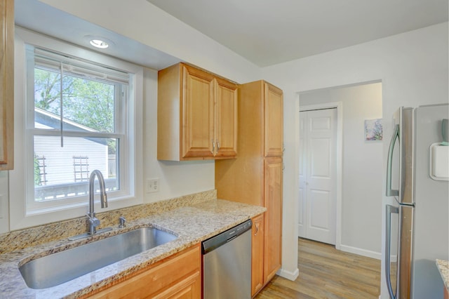2714 18th Ave S, Minneapolis, MN 55407 - kitchen with appliances with stainless steel finishes, a sink, light wood-style floors, light stone counters, and baseboards