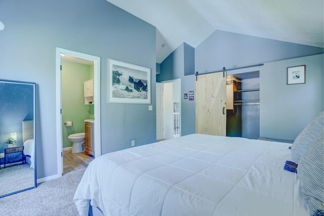2714 18th Ave S, Minneapolis, MN 55407 - carpeted bedroom with vaulted ceiling, a barn door, connected bathroom, and a spacious closet