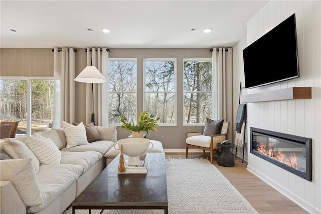 10391 Glacier Ln N, Maple Grove, MN 55369 - living room with a glass covered fireplace, plenty of natural light, light wood finished floors, baseboards, and recessed lighting