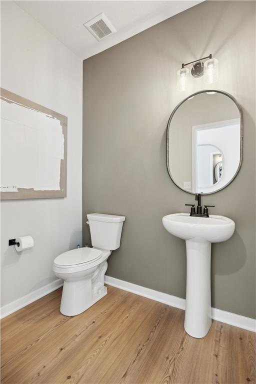 10391 Glacier Ln N, Maple Grove, MN 55369 - half bath with wood finished floors, toilet, and baseboards