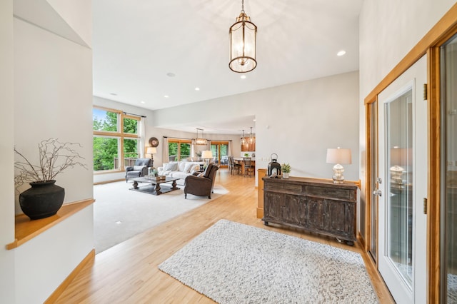 living area with a chandelier, wood finished floors, recessed lighting, and baseboards