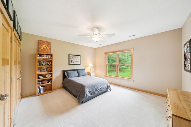 bedroom with light carpet, baseboards, and a ceiling fan