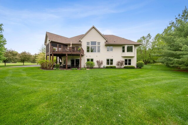 back of property with a lawn, a wooden deck, and a shingled roof