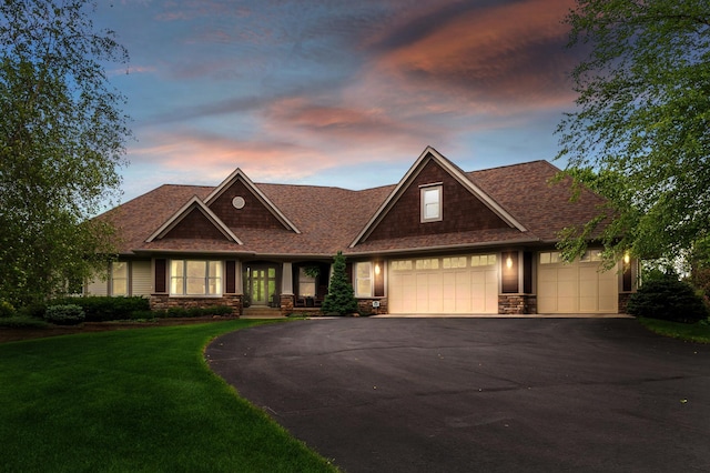 craftsman inspired home with stone siding, driveway, a garage, a lawn, and a shingled roof
