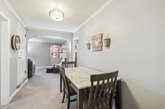 1224 Grotto St N, Saint Paul, MN 55117 - dining space with crown molding, a textured ceiling, arched walkways, light carpet, and baseboards