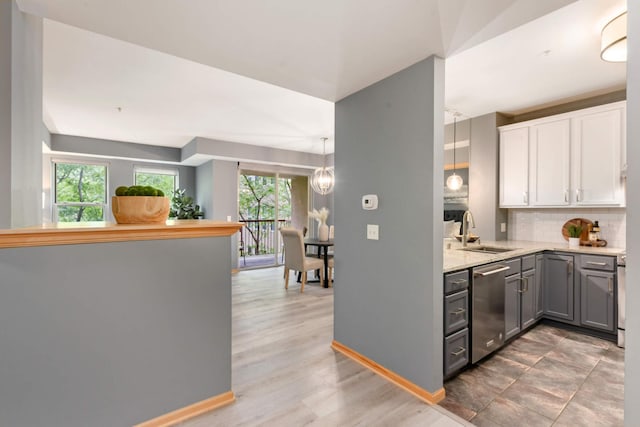 kitchen with a sink, stainless steel dishwasher, gray cabinetry, backsplash, and white cabinets