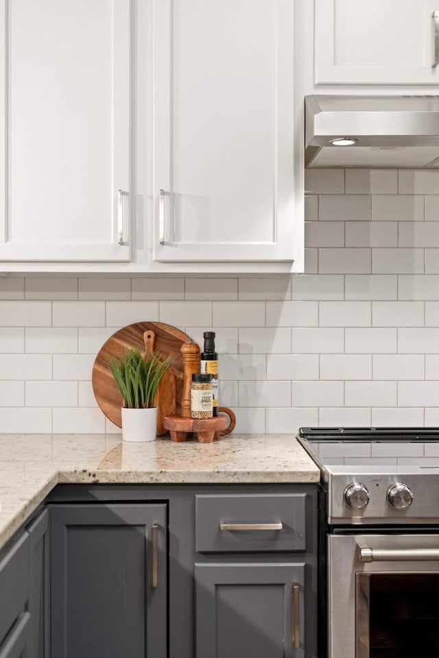kitchen with stainless steel electric range oven, gray cabinetry, tasteful backsplash, and range hood