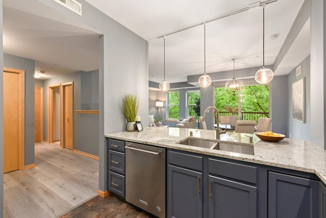 kitchen with a sink, dishwasher, gray cabinetry, and light stone counters