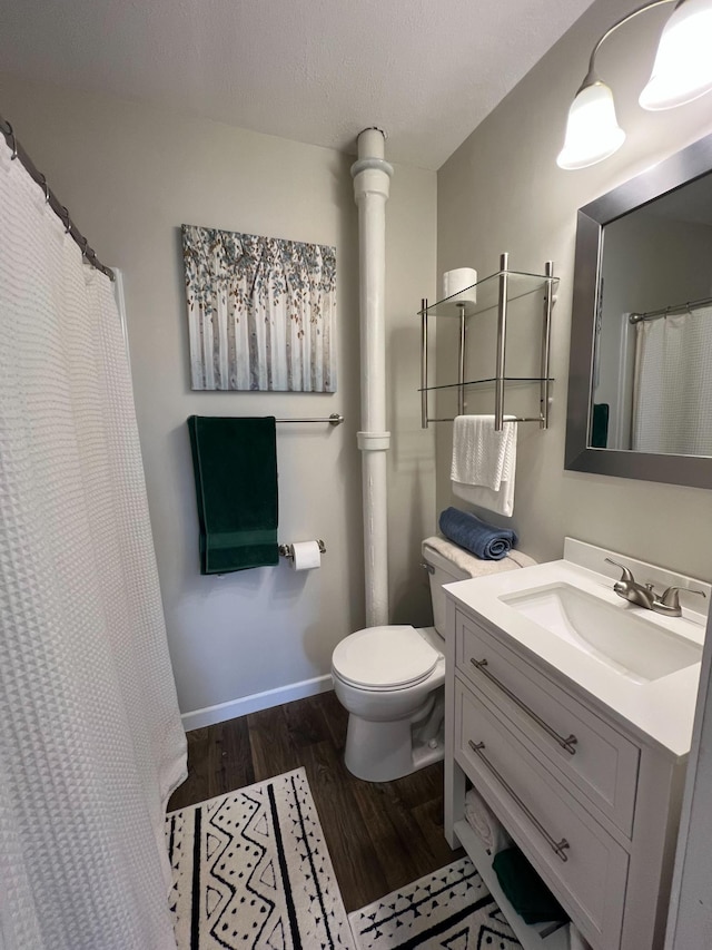 225 State St, Buhl, MN 55713 - bathroom with wood finished floors, toilet, vanity, and baseboards