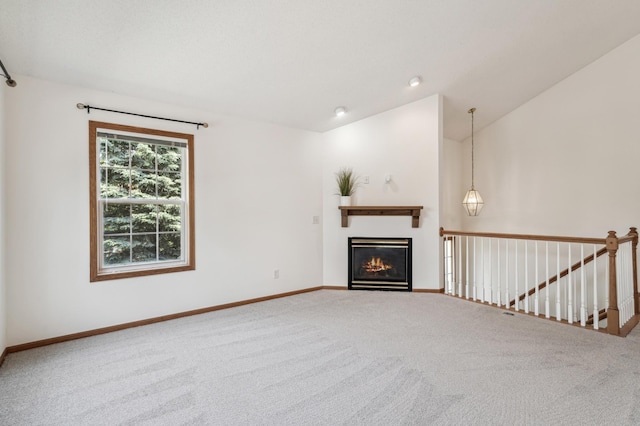 7379 Devin Ln, Shakopee, MN 55379 - unfurnished living room with carpet flooring, a glass covered fireplace, and baseboards
