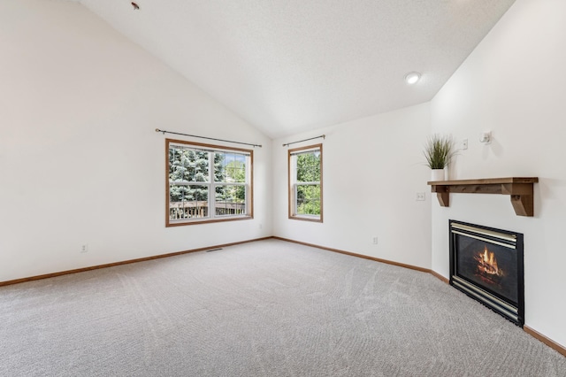 7379 Devin Ln, Shakopee, MN 55379 - unfurnished living room featuring lofted ceiling, baseboards, carpet, and a glass covered fireplace
