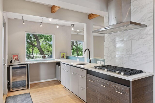5016 Shady Oak Rd S, Minnetonka, MN 55343 - kitchen featuring island exhaust hood, wine cooler, a sink, stainless steel gas stovetop, and light wood finished floors