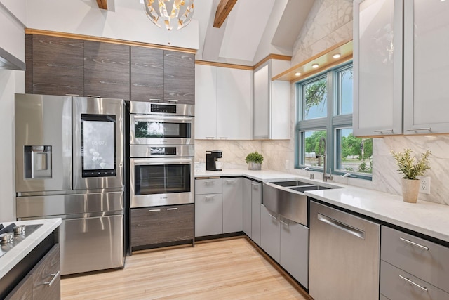 5016 Shady Oak Rd S, Minnetonka, MN 55343 - kitchen featuring stainless steel appliances, tasteful backsplash, a sink, light wood-style floors, and a chandelier